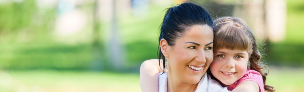 Happy mother and daughter laughing together outdoors